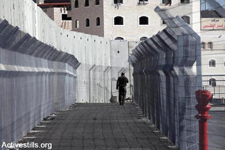 Un résident de Jérusalem-Est marchant le long du mur en direction d'un check-point