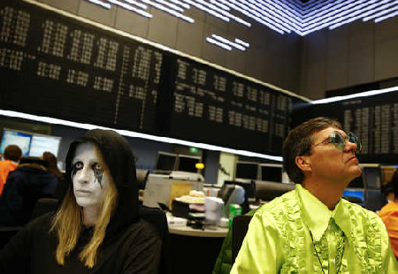 Share traders dressed in a carnival costumes work a their desks ar the stock exchange on Shrove Tuesday in Frankfurt